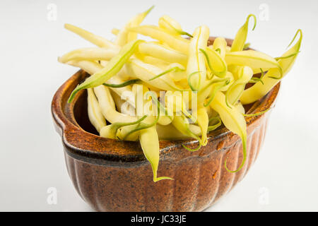 Il giallo di fagioli in una ciotola in ceramica isolata su sfondo bianco Foto Stock