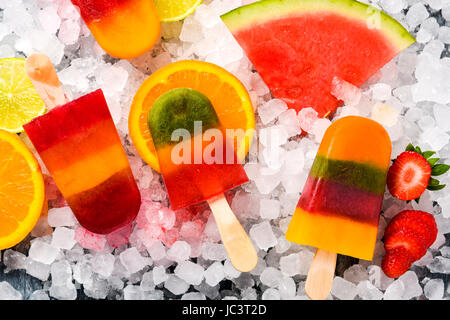 Alta angolazione alcuni dei differenti in casa ice pops, realizzate con diversi succhi di frutta naturali e pezzi di frutta come cocomero, limone, pesca, l Foto Stock