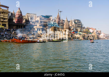 Fumo di cremato corpi morti è in aumento a Manikarnika Ghat presso il fiume sacro Gange nel sobborgo Godowlia Foto Stock