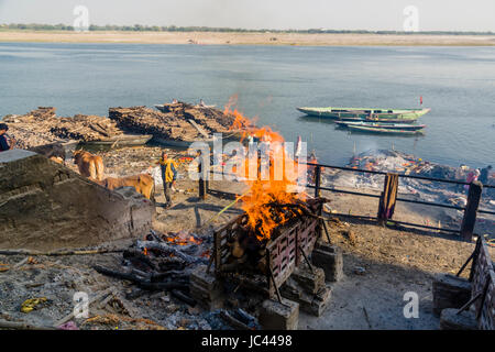 Fumo di cremato corpi morti è in aumento a manikarnika ghat presso il fiume sacro Gange nel sobborgo godowlia Foto Stock