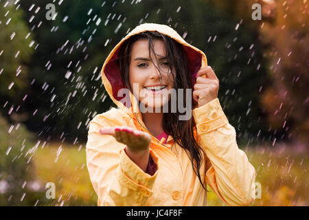 Bella giovane donna in impermeabile giallo Foto Stock