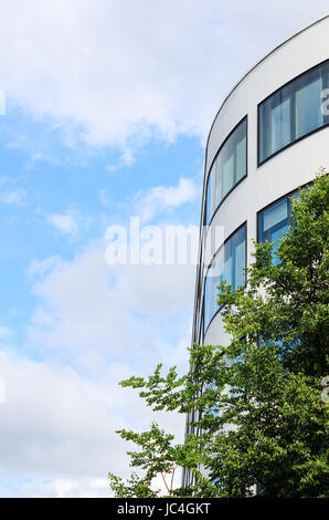 Moderno edificio con mirroring e windows tree contro il cielo blu come sfondo con copy-spazio posto libero per il testo Foto Stock