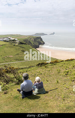 Due persone che guardano la vista verso la vite senza fine di testa, Rhossili. Gower, Wales, Regno Unito Foto Stock