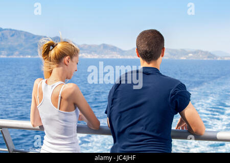 Due giovani donna e uomo vela su una nave e godendo la loro estate mare vacanze. Foto Stock