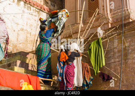 Le donne stanno mettendo a servizio lavanderia a secco presso il fiume sacro Gange a dashashwamedh ghat, principale ghat, nel sobborgo godowlia Foto Stock