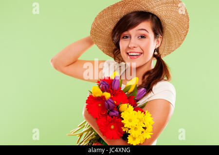 Sorridente brunet donna con cappello e fiore di primavera Foto Stock