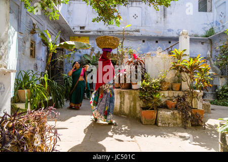 Una donna che porta un cestello sul suo capo e la vendita di beni, è camminare lungo le strade del borgo godowlia Foto Stock