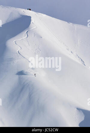 Professional Snowboarder Robin Van Gyn, giostre di polvere fresca in una giornata di sole mentre lo snowboard in Haines, Alaska. Foto Stock