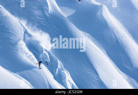 Professional Snowboarder Robin Van Gyn, giostre di polvere fresca in una giornata di sole mentre lo snowboard in Haines, Alaska. Foto Stock