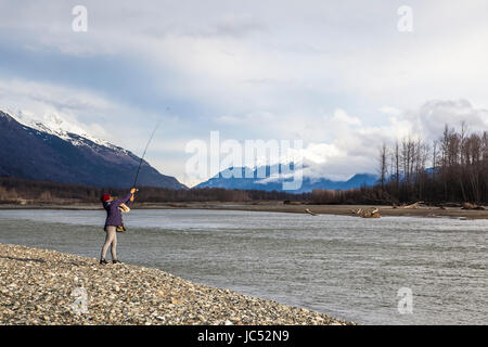 Professional Snowboarder Helen Virgili hanno, pesci sul fiume Chilkat su un giorno verso il basso dallo snowboard durante un viaggio a Haines, Alaska. Foto Stock