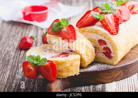 In casa strawberry shortcake rotolo di torta con crema di formaggio panna montata, perfetta estate stagione dessert servito su rustiche di legno Foto Stock