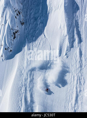 Professional Snowboarder Marie Francia Roy, corse di polvere fresca in una giornata di sole mentre lo snowboard in Haines, Alaska. Foto Stock