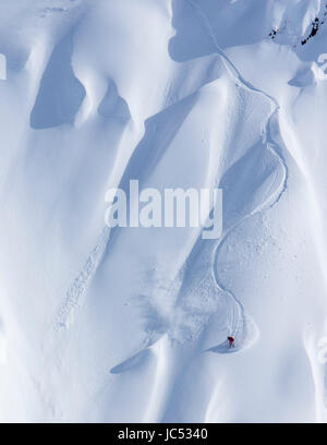 Professional Snowboarder Marie Francia Roy, corse di polvere fresca in una giornata di sole mentre lo snowboard in Haines, Alaska. Foto Stock