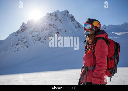 Professional Snowboarder Marie Francia Roy, guarda le montagne dopo a cavallo di un divertente correre in una giornata di sole in Haines, Alaska. Foto Stock