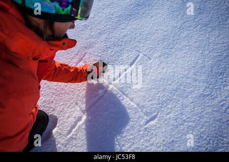 Professional Snowboarder Robin Van Gyn, utilizza una valanga di faro rotante e segni nella neve per dimostrare un modello di ricerca utilizzato sulla griglia durante la ricerca e salvataggio avalance. Foto Stock