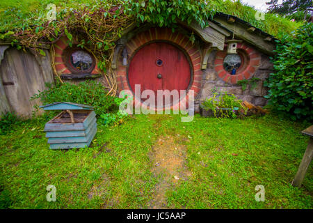 Isola del nord, Nuova Zelanda - 16 Maggio 2017: Hobbit house con porta rossa, hobbiton set cinematografico, sito realizzato per film: Hobbit e Il signore degli anelli in Matamata Foto Stock