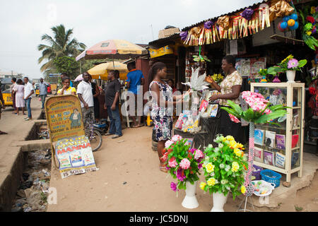 Una femmina di negoziante al di fuori del suo negozio, Nigeria, Africa Foto Stock