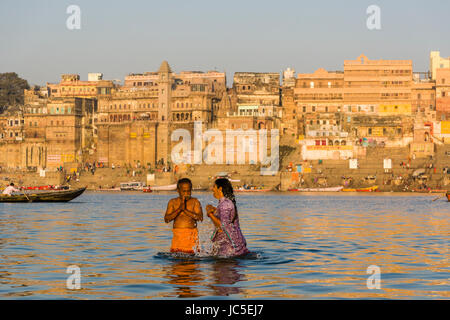 I pellegrini sono tenendo bagno e pregare sui banchi di sabbia di fiume santo Ganges, panorama di Dashashwamedh Ghat, principale Ghat, nella distanza Foto Stock