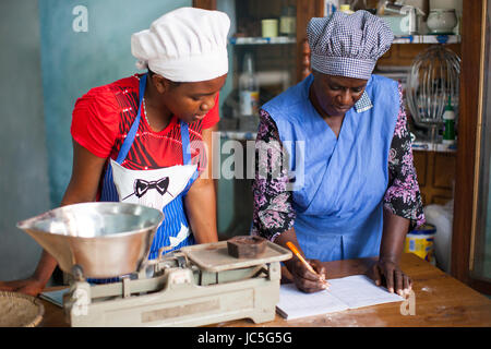 Il bakers femmina nella loro cucina, Tanzania, Africa Foto Stock