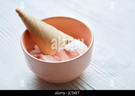 Piastra del gelato scoop e coni di cialda su sfondo bianco. Foto Stock