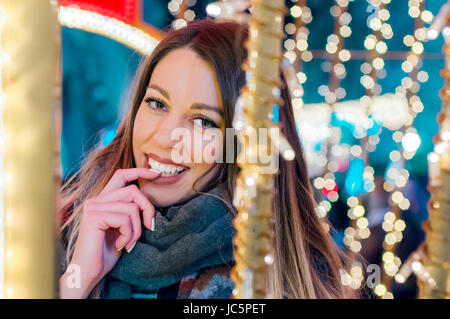 Bella giovane donna godendo di Natale o Capodanno la notte su una strada di città. Giovane e bella bruna donna godendo di Natale o Capodanno la notte su una Foto Stock