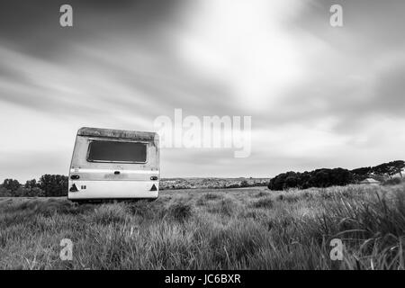 Abbandonato trascurato caravan sinistra in campo sulla periferia della città Foto Stock