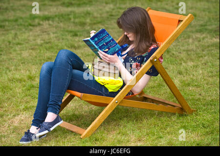 Giovane donna libro lettura rilassante in sedia a sdraio a Hay Festival della letteratura e delle Arti 2017 Hay-on-Wye Powys Wales UK Foto Stock