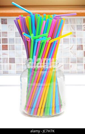 In plastica colorata di bere cannucce in vetro trasparente jar Foto Stock