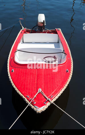 Piccolo motoscafo rosso fissato con delle corde di un porto Foto Stock