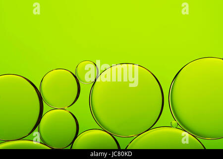 Gocce di olio in acqua, bolle sul verde sfondo astratto Foto Stock