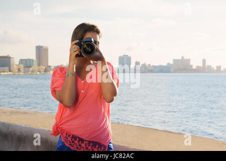 Ritratto di giovane ragazza di La Habana, Cuba, scattare foto e foto guardando la telecamera attraverso il mirino Foto Stock