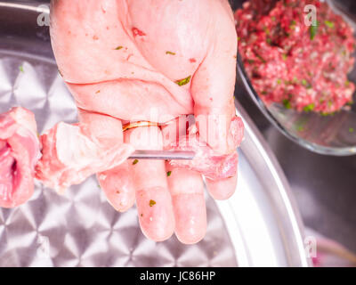 Primo piano di uno chef entrando in pezzi di carne su uno spiedino, rendendo shish kebab Foto Stock