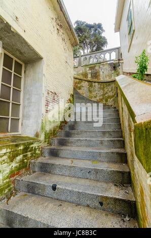 Il penitenziario di Alcatraz island, ora un museo, a San Francisco, California, Stati Uniti d'America. Una vista di un vecchio, ammuffito, scala di pietra che conduce alla Cellhouse sulla storica prigione federale. Foto Stock