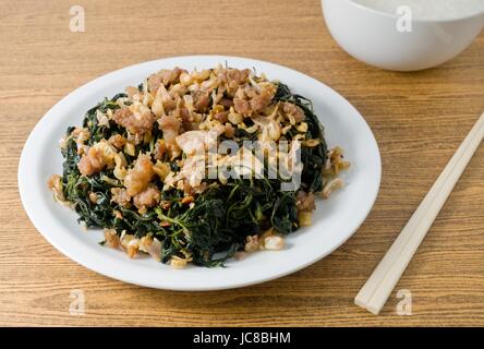 Cinese tradizionale cibo, saltate in padella Foglie di iuta o Mulukhiyah foglie con carne macinata di maiale, Garlics e fermentati di soia con Soft riso bollito. Foto Stock