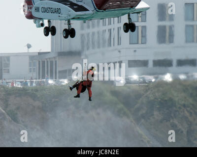 Sulla baia Newquay, Cornwall, Regno Unito. 14 Giugno, 2017. I guardacoste volontari uniti RNLI soci in un'operazione combinata ad un ponte aereo una donna fparticipating in coasteering.a Newquay. affetti da sospetti problemi di cuore la vittima è stato trasferito in aereo a Royal Cornwall Hospital Truro in guardia costiera Sikorsky S92 elicottero. Esito positivo è previsto. Sulla baia Newquay, Newquay, Cornwall, Regno Unito.14 Giugno, 2017. Credito: Robert Taylor/Alamy Live News Foto Stock