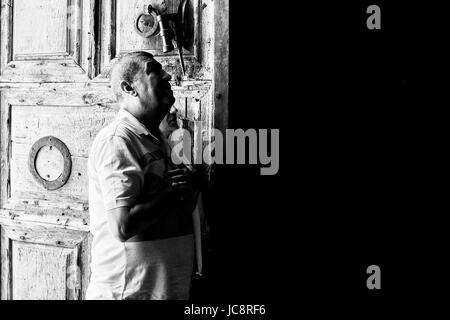 Gerusalemme, Israele. 14 Giugno, 2017. Un uomo e una donna stanno in soggezione all'ingresso della chiesa del Santo Sepolcro. Foto Stock