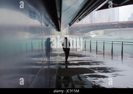 Chicago, Stati Uniti. Xiv Jun, 2017. Un lone womans peso sotto il ponte a fianco del fiume Chicago sotto Wabash Avenue come il tuono tempesta si riversa giù, Credito: Almos Lataan/Alamy Live News Foto Stock