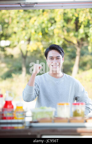 Giovani sorridente fiducioso uomo a partire camion alimentari Foto Stock