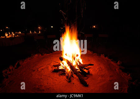 All'aperto il fuoco di legno che brucia ardentemente durante il buio della notte Foto Stock