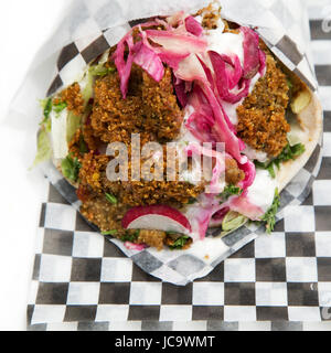 Un falafel wrap è servita a Calgary, Canada. Immigrazione e influenze globali significa una vasta varietà di cucine sono serviti nelle principali città. Foto Stock