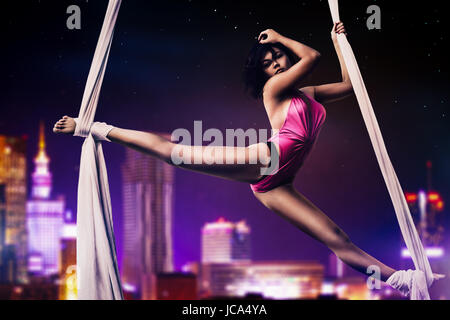 Giovane donna ginnasta notte sulla città moderna di sfondo Foto Stock