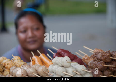 Bangkok, Thailandia, 27-Ottobre-2007: una donna seduta dietro tutti i tipi di cibo in Bangkok. Foto Stock