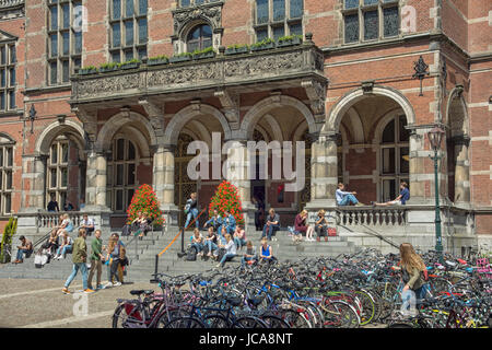 Gli studenti seduti sui gradini di ingresso principale del tappeto Università di Groningen nei Paesi Bassi Foto Stock