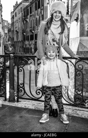 Venezia. Itinerario insolito. A piena lunghezza Ritratto di sorridere alla moda di madre e figlia i turisti a Venezia, Italia in inverno Foto Stock