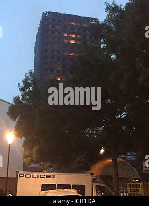 Gli incendi brucia ancora dopo un incendio si propagò 24 piani Grenfell Torre nel West London. Foto Stock