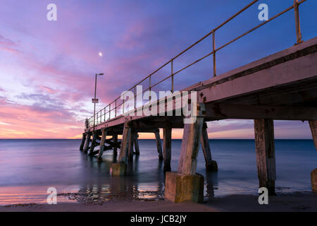 Il tramonto visto dal lato del molo Normanville in Sud Australia, che si trova sulla penisola di Fleurieu. Slow shutter a velocità utilizzata rendendo l'acqua Foto Stock