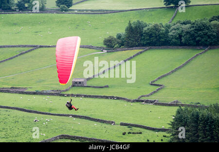 Un membro del Dales deltaplano e parapendio club vola un parapendio vicino cervi cadde nel Yorkshire Dales National Park. Foto Stock