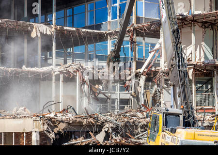 Costruzione di opere di demolizione. Un escavatore da demolizione la demolizione di un fermaglio blocco ufficio, West Bridgford, Nottinghamshire, England, Regno Unito Foto Stock