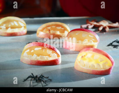 Scary Halloween decorazioni per trucco-o-trattare favori o parte tabella decorazioni con schiusi aprire apple bocche con denti e ragni ridotta in un divertente concetto fatti in casa Foto Stock