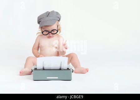 Little baby la digitazione con una macchina da scrivere Foto Stock